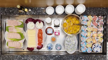 A buffet setup with various food items and condiments.