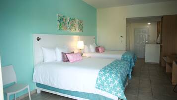 A bedroom with two beds, a nightstand, a chair, and a door leading to a bathroom.