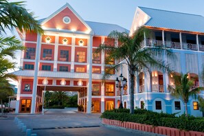 A multi-story hotel with a prominent entrance, balconies, and a well-lit facade. - Pelican Bay Resort at Lucaya (Freeport)