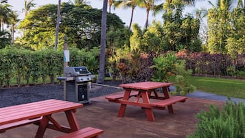 A patio area with picnic tables and a grill.