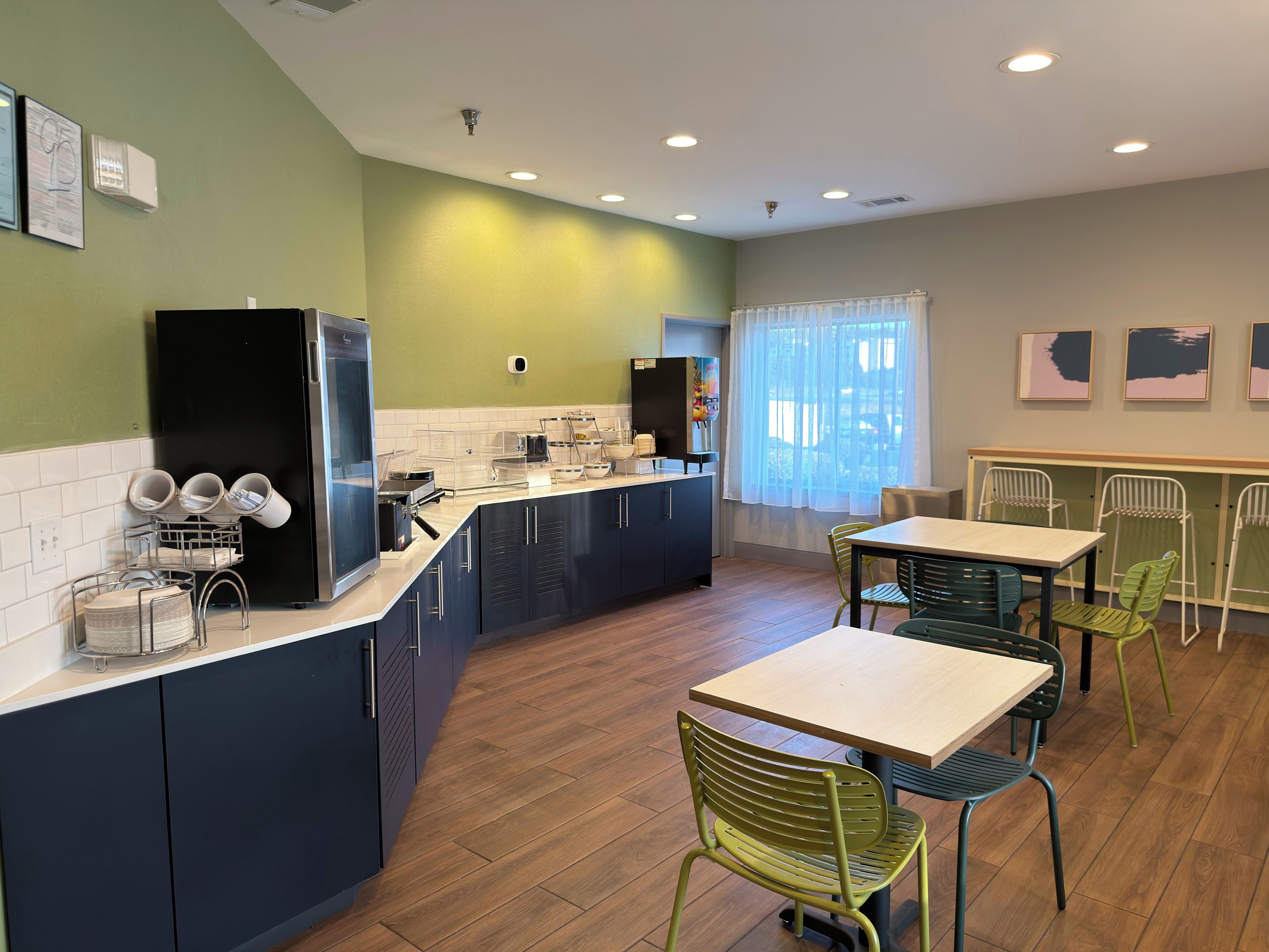 Eine moderne Küche mit Kühlschrank, Spüle und Arbeitsfläche, sowie ein Essbereich mit Stühlen und Tisch.