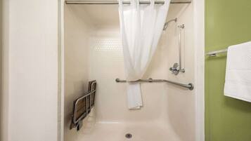 A bathroom with a bathtub, a shower curtain, a grab bar, and a towel rack.