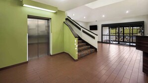 A spacious lobby with a staircase, a large elevator, and a view of the outdoors through a glass door. - Sleep Inn Athens I-65 (Athens)
