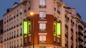 Un immeuble à plusieurs étages doté d’une façade incurvée, de grandes fenêtres et de balcons.