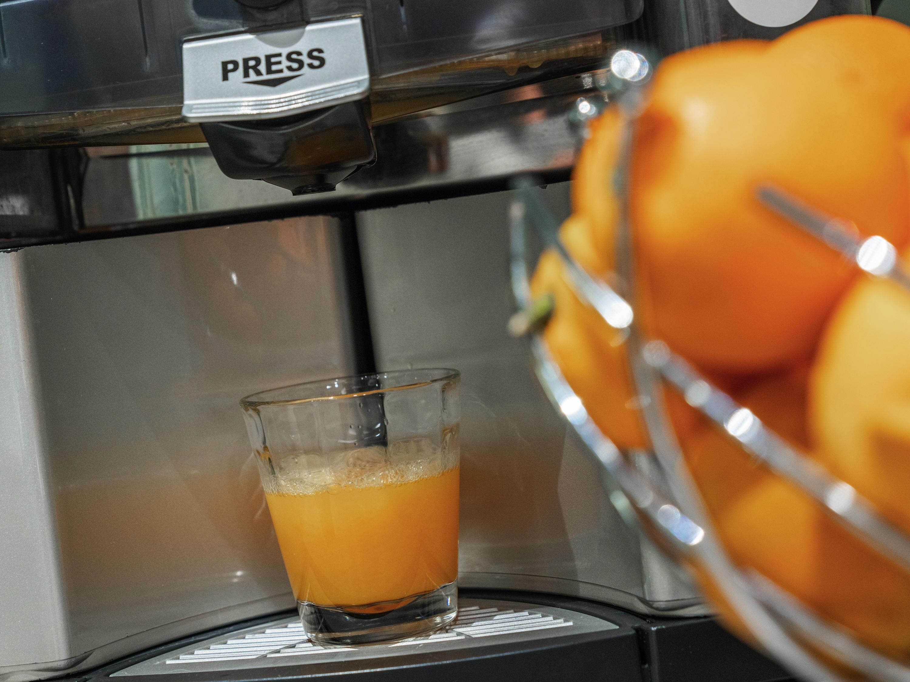 A coffee machine dispensing coffee into a glass cup.