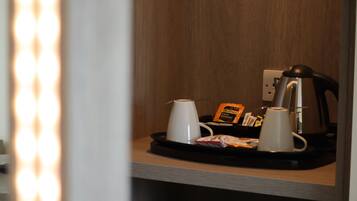 A breakfast tray with a coffee maker, two cups, and a packet of Twinings English Breakfast tea.
