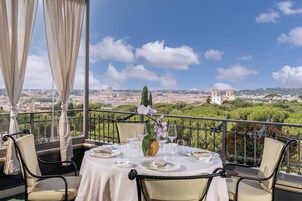 Tavola imbandita con vista sulla città, che include una cupola e torri.
