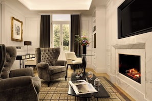 A living room with a fireplace, a television, and a dining area with a table and chairs.