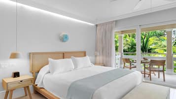 A modern bedroom with a large bed, bedside tables, a ceiling fan, and a view of lush greenery outside.