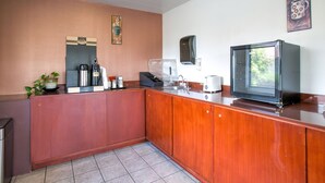 Una cocina equipada con cafetera, tostadora y microondas.