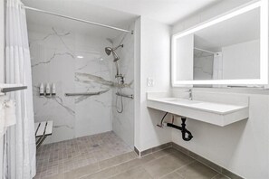 A modern bathroom with a shower, a sink, and a mirror. - Travelodge Salinas (Salinas)