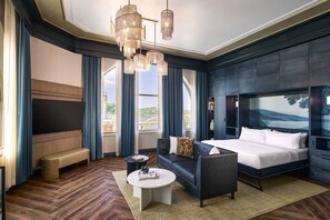 Une chambre d’hôtel moderne avec un grand lit, un canapé, une table basse et un téléviseur.