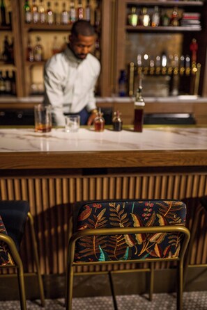 En bar med disk, barstole og en bartender.