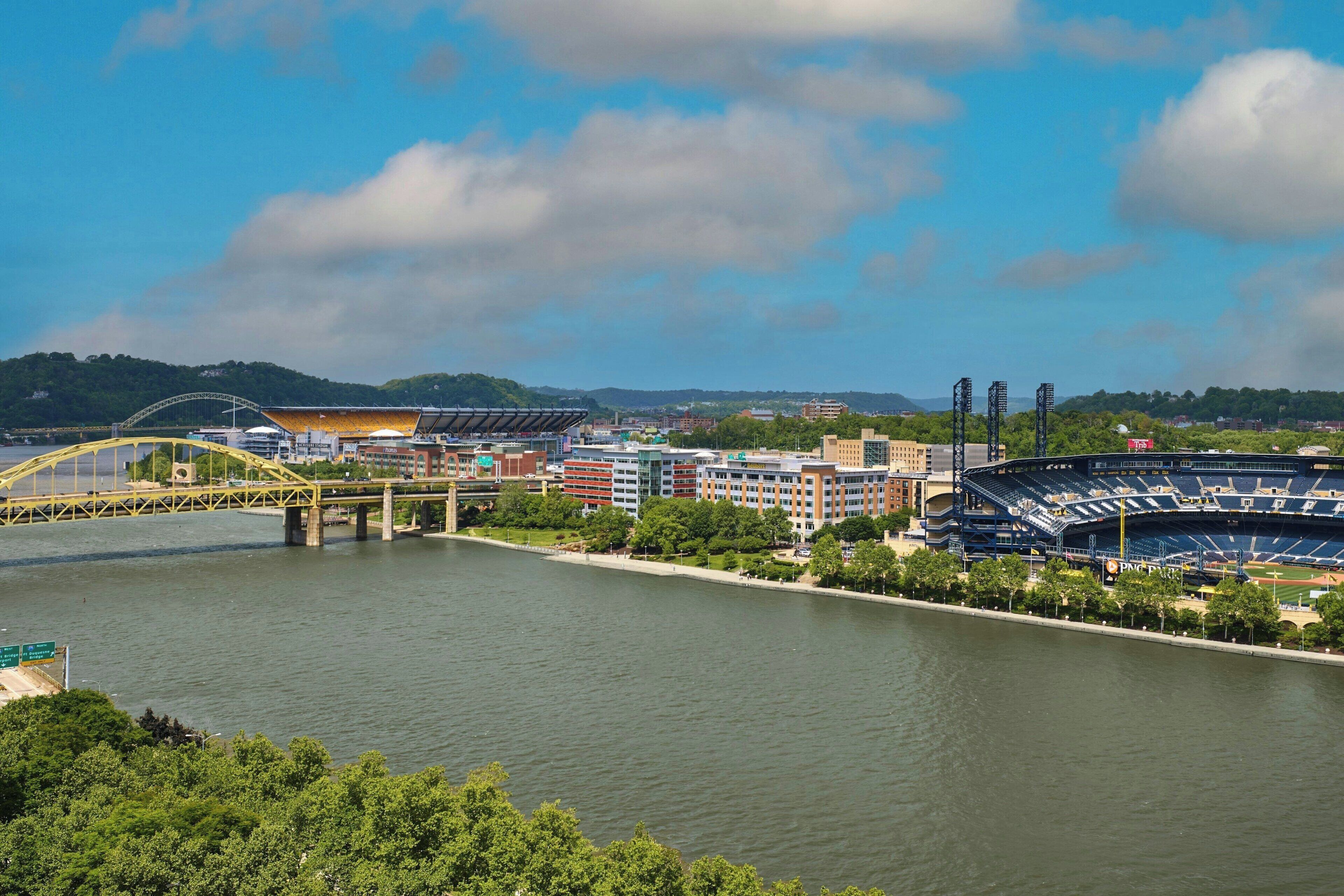 A stadium with a large seating area, a bridge, and a river.