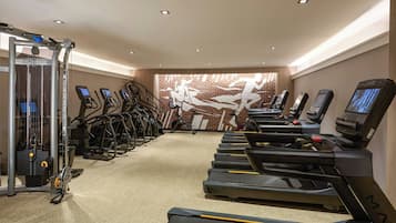 A gym with treadmills, elliptical machines, and weight machines.