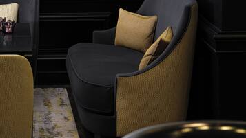 Un comedor moderno con una silla tapizada de color negro, una silla amarilla estampada y una mesa preparada para comer.