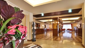 A hotel lobby with a reception desk, seating area, and a decorative plant arrangement. - Best Western Classic Hotel (Reggio nell'Emilia)