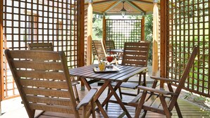 A wooden deck with a table and chairs, a glass of red drink, and a tray with snacks. - Best Western Classic Hotel (Reggio nell'Emilia)