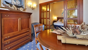 A hotel room with a wooden dining table, chairs, a cabinet, a painting, and a large window. - Best Western Classic Hotel (Reggio nell'Emilia)