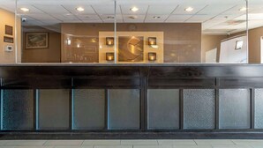 A reception area with a glass partition, a clock, and recessed lighting. - Comfort Inn & Suites Jackson North (Jackson)