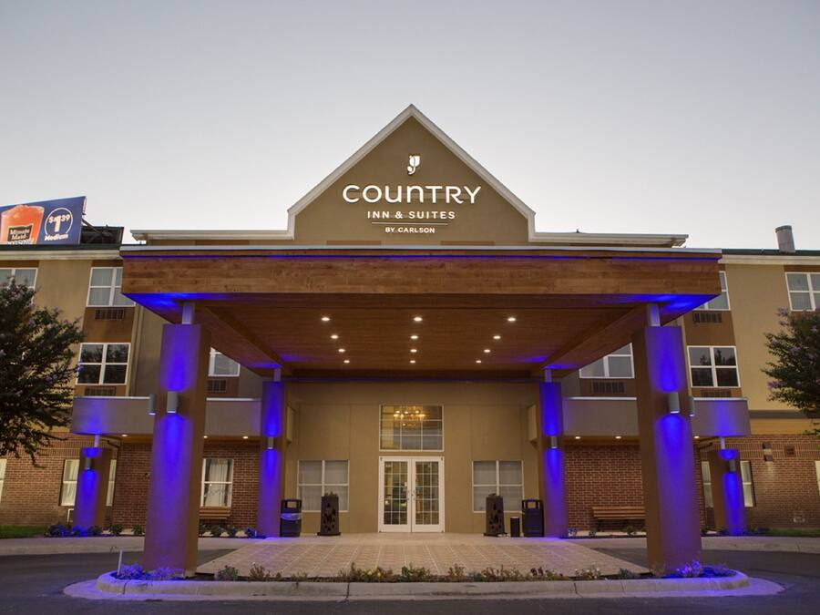 A Country Inn & Suites building with a prominent entrance, a covered outdoor area, and a sign indicating the name and brand.