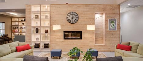 Un salon moderne avec une grande horloge murale, des étagères intégrées et une cheminée.