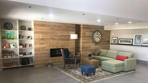 Ein modernes Wohnzimmer mit einer Couch, einem Couchtisch, einem Bücherregal und einem Kamin.