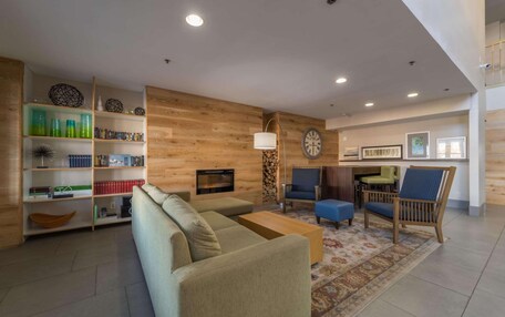 A modern living room with a sofa, coffee table, and bookshelves.