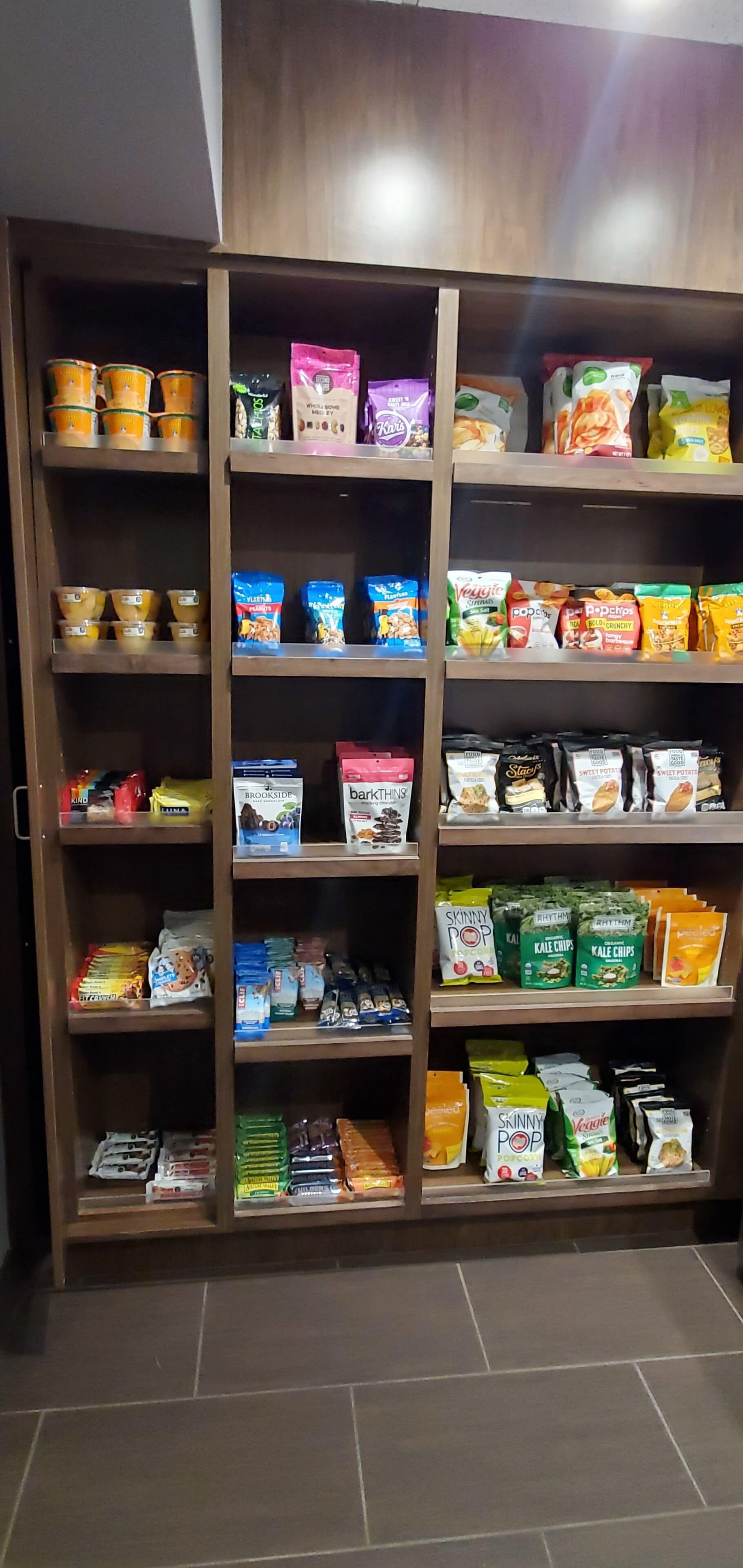 A pantry with shelves stocked with various food items including snacks, cereals, and baking supplies.