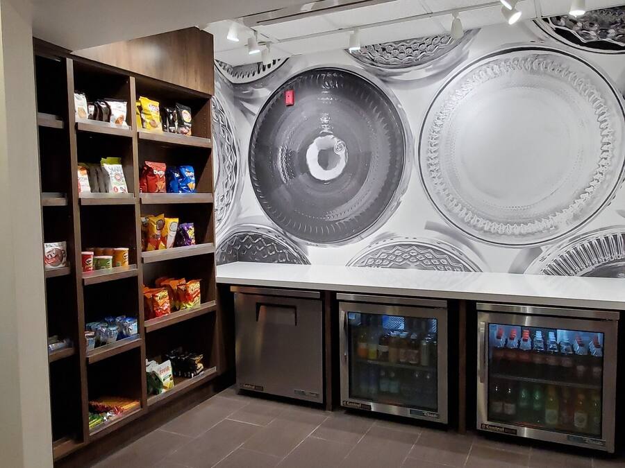 Une pièce spacieuse ornée d’une grande fresque murale, dotée d’étagères intégrées remplies d’en-cas et d’un distributeur automatique.