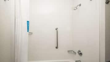 A shower with a handheld showerhead, a handheld showerhead, and a handheld showerhead.