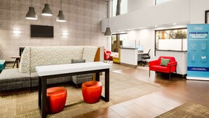 A modern hotel lobby with a seating area, a reception desk, and a large promotional banner. - Hampton Inn & Suites Las Vegas-Henderson (Henderson)