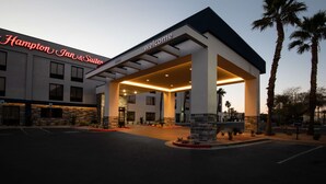A Hampton Inn & Suites with a 'Welcome' sign, stone facade, and palm trees. - Hampton Inn & Suites Las Vegas-Henderson (Henderson)