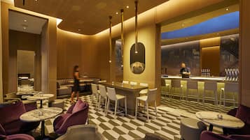 A modern bar area with a checkered floor, bar stools, and a bar counter.
