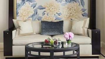 A living room with a sofa, a coffee table, and a large floral wall mural.