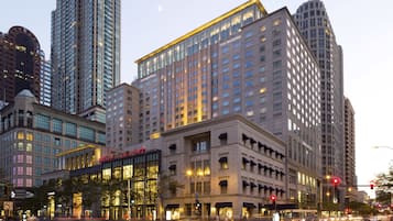 A multi-story hotel with a prominent glass facade, large windows, and a classic architectural design.