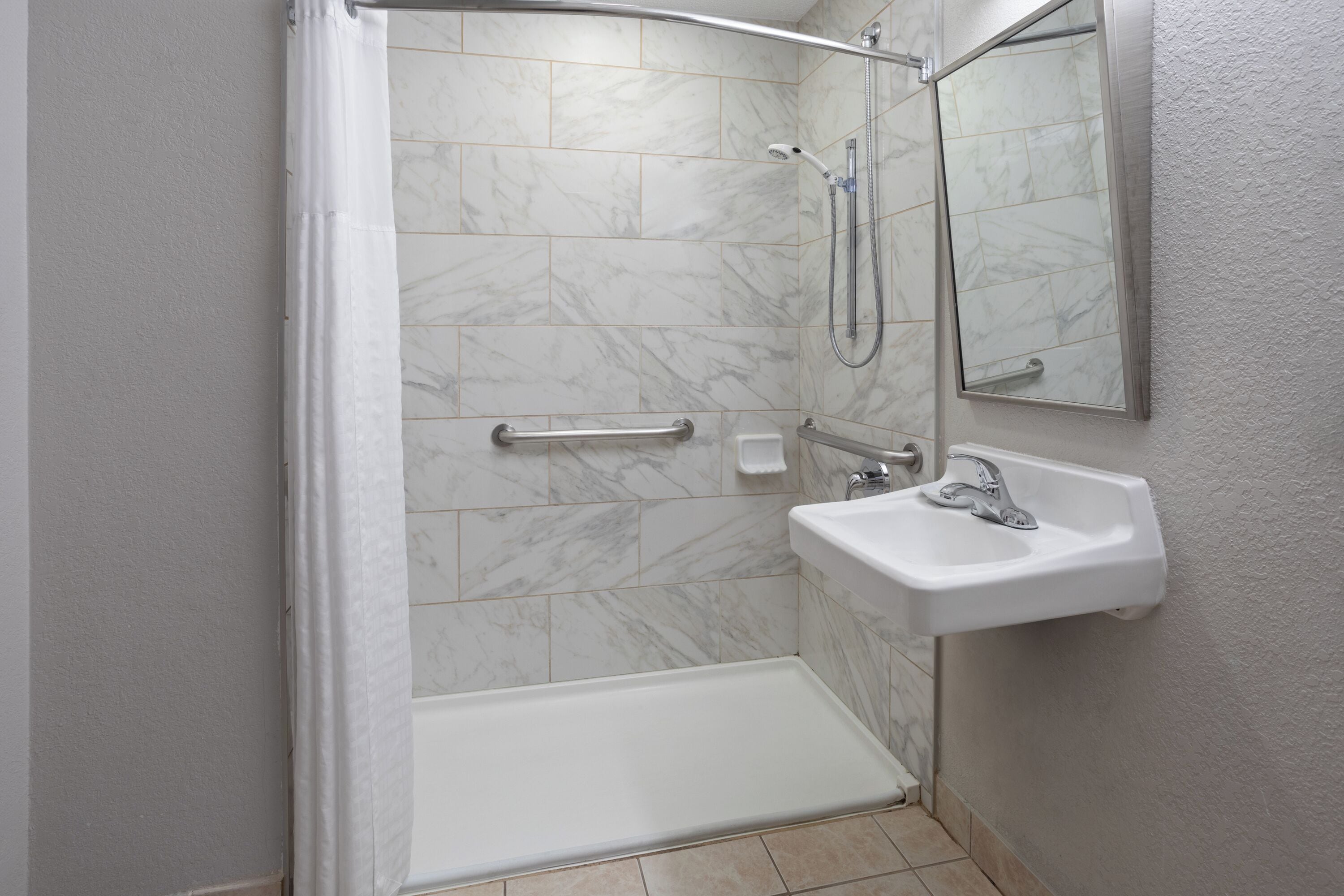 Un baño con ducha, lavabo y espejo.