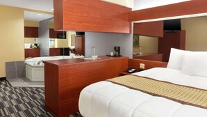A hotel room with a large bed, a wooden desk, a sink, and a mirror. - Microtel Inn & Suites by Wyndham Thomasville/High Point/Lexi (Thomasville)