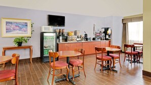 A hotel room with a dining area, a refrigerator, a microwave, a coffee machine, and a television. - Microtel Inn & Suites by Wyndham Thomasville/High Point/Lexi (Thomasville)