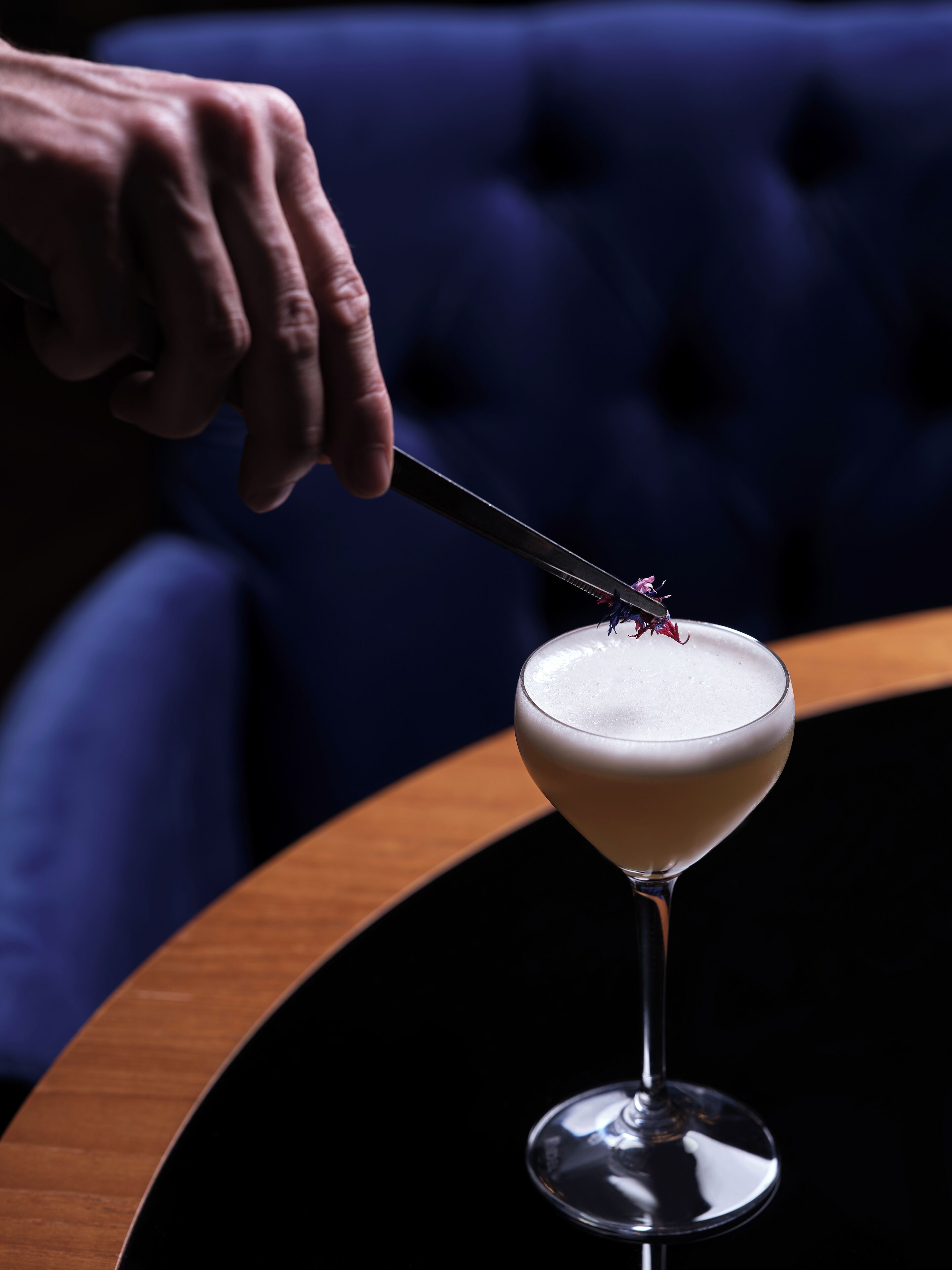 Un verre à martini sur une table ronde, avec un fond sombre.