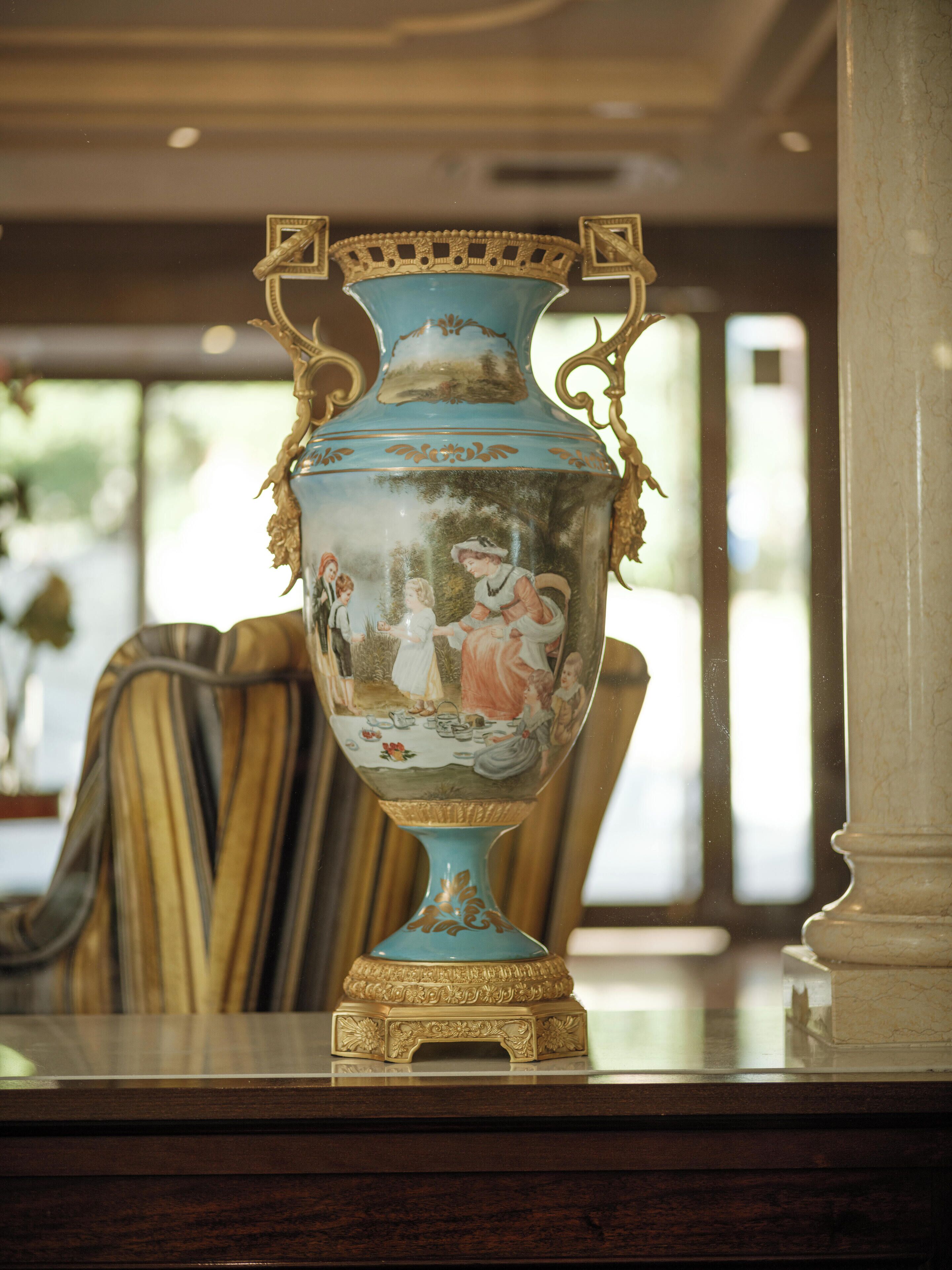 Un vaso decorativo con motivi elaborati e dettagli dorati su un tavolo.