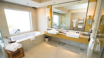 Un baño moderno con una bañera grande, dos lavamanos, un espejo amplio y un ventanal que proporciona luz natural.