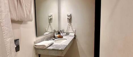 Un baño pequeño con inodoro, lavamanos y espejo.