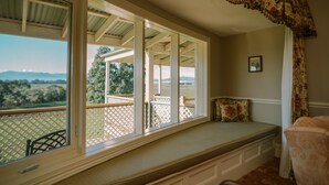 A room with a large window overlooking a deck and landscape. - Chateau Yering Hotel (Yering)