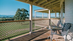A covered outdoor area with a table and chairs, a view of the landscape, and a wooden ceiling structure. - Chateau Yering Hotel (Yering)