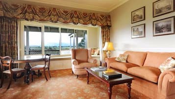 A living room with a sofa, armchairs, a coffee table, and a window with a view.