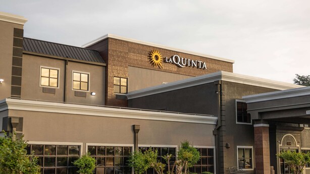 A hotel with a modern facade, large windows, and a prominent logo.