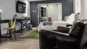 Una habitación de hotel moderna con una cama, un escritorio, una silla y un televisor.