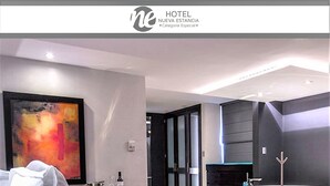 Quarto de hotel moderno com uma cama grande, uma banheira e um quadro na parede.