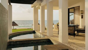 A pool area with a view of the ocean, a thatched umbrella, and a seating area with chairs. - Maroma, A Belmond Hotel, Riviera Maya (Playa del Carmen)